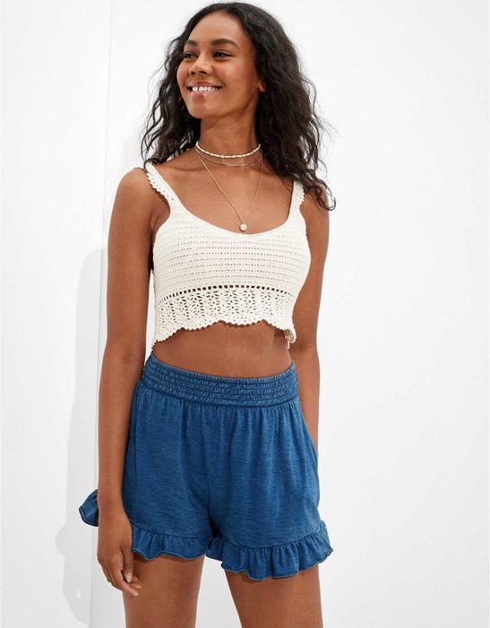 Model styling the ruffle shorts with a white crop top