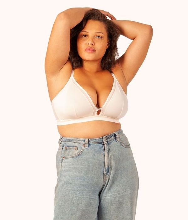 A reviewer shows off the white version of the bra for a clean and classic look.