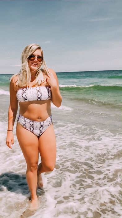 A reviewer wears the snake-print version of the bandeau bikini for a bold beach style.