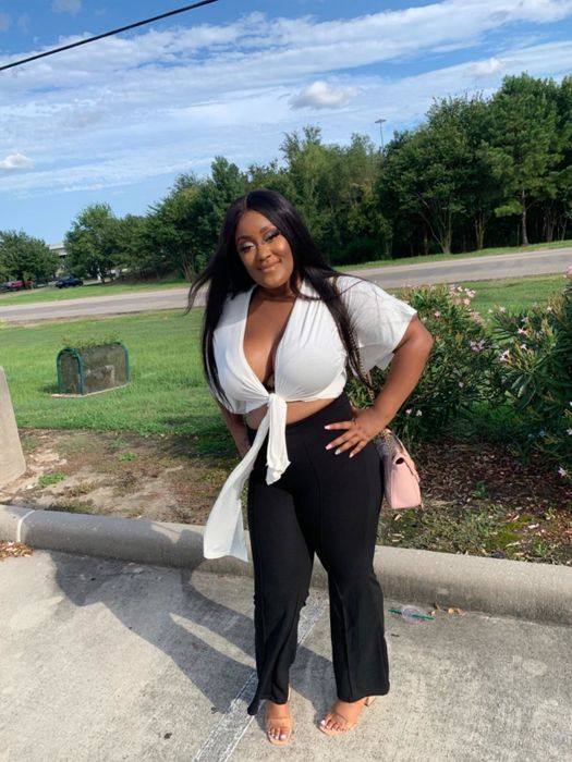 A reviewer shows off the white tie-front top in a photo.