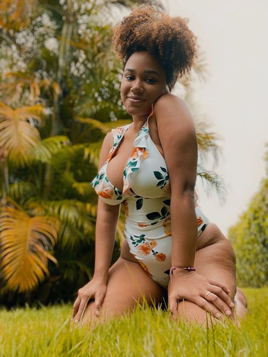 A reviewer sports the white and floral version of this stunning swimsuit for a fresh, bright look.