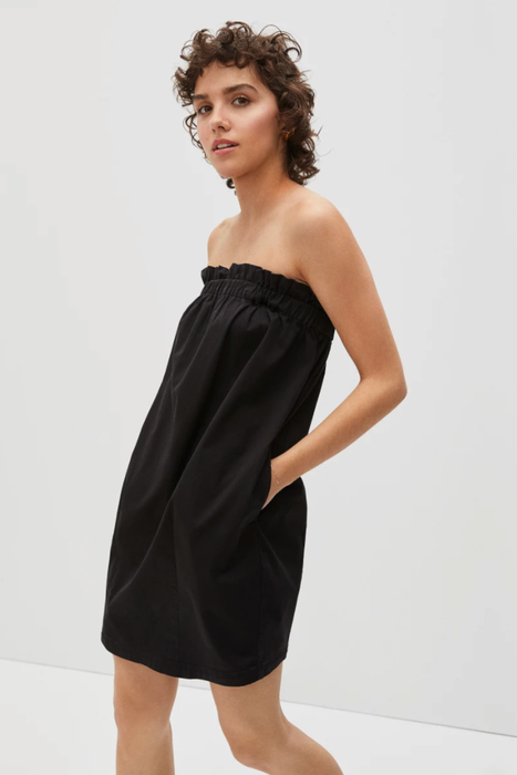 Model wearing the black dress with the straps removed