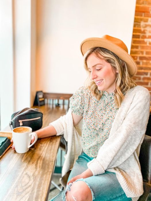Another reviewer styling the blouse with jeans and a neutral tan hat