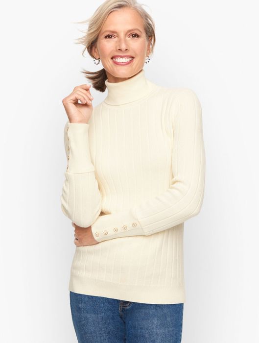 A model showcasing an ivory sweater.