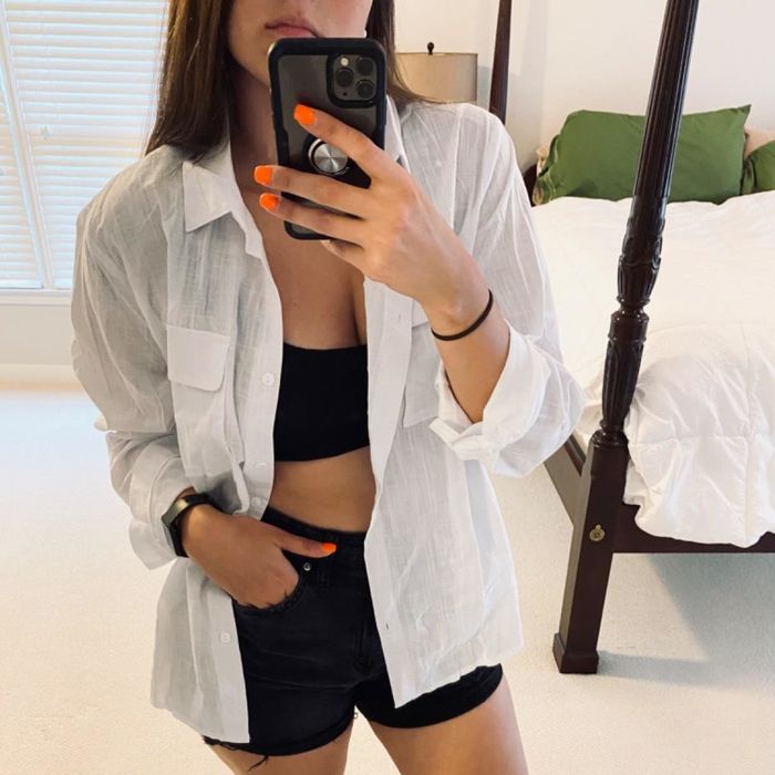 A reviewer rocking the white shirt worn open with shorts.