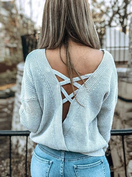 Back view of a model wearing the sweater in light grey