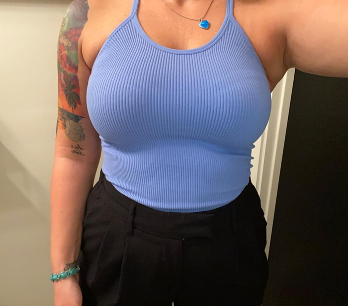 A reviewer sporting a blue top paired with black bottoms.
