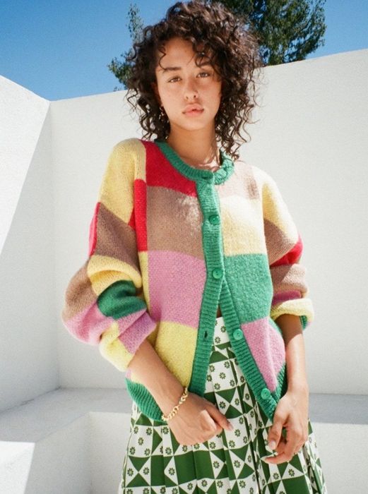 A model wearing the checkered cardigan over a skirt