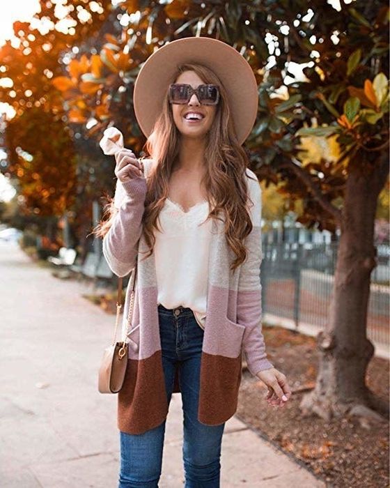 Model styled in jeans, a cami, and a multicolor cardigan in shades of gray, brown, and pink, embodying fall hues.