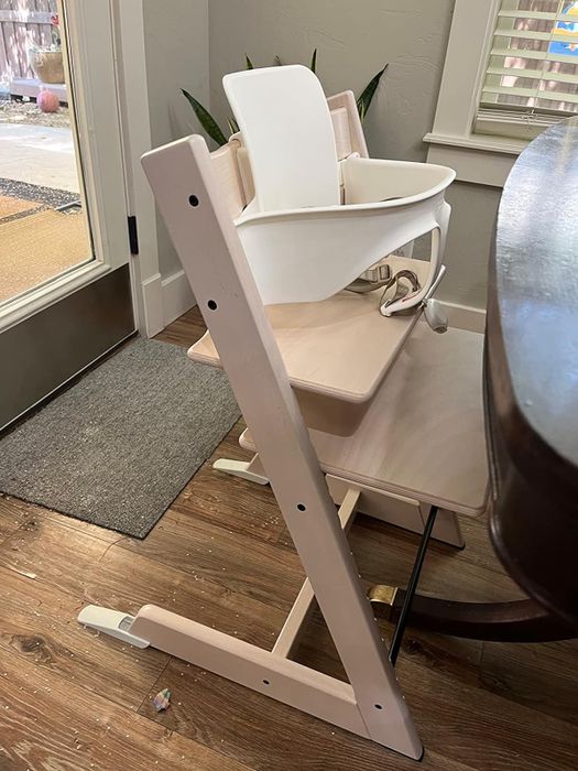 A stylish modern high chair with a sleek design, presented in a boutique-like display for shopping purposes