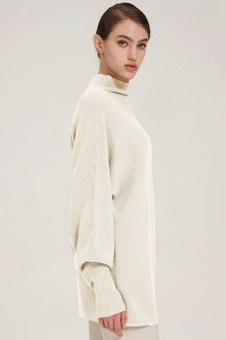 Model showcasing a white sweater