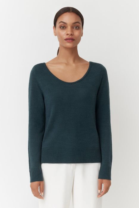 A model showing off a jade-colored sweater.