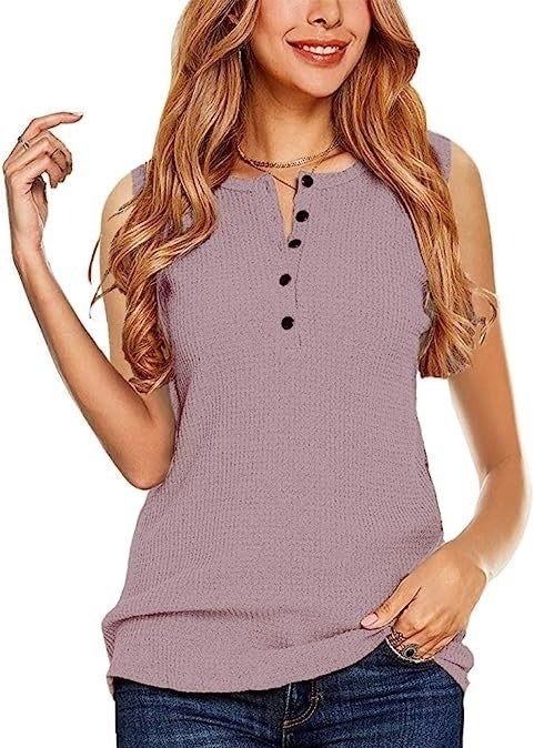 Woman wearing a sleeveless buttoned top paired with jeans.