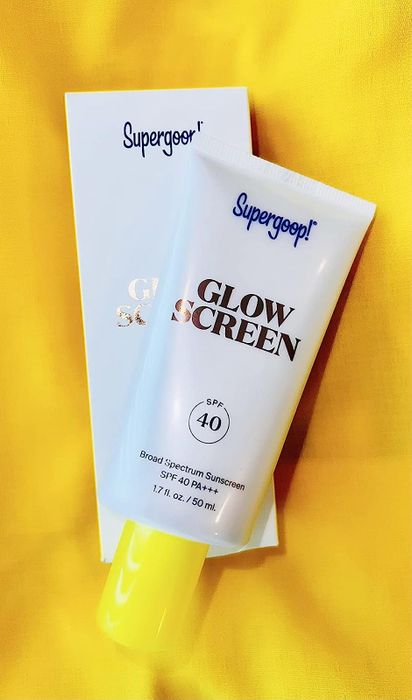A tube of Supergoop's Glowscreen sunscreen, radiating protection and shine.
