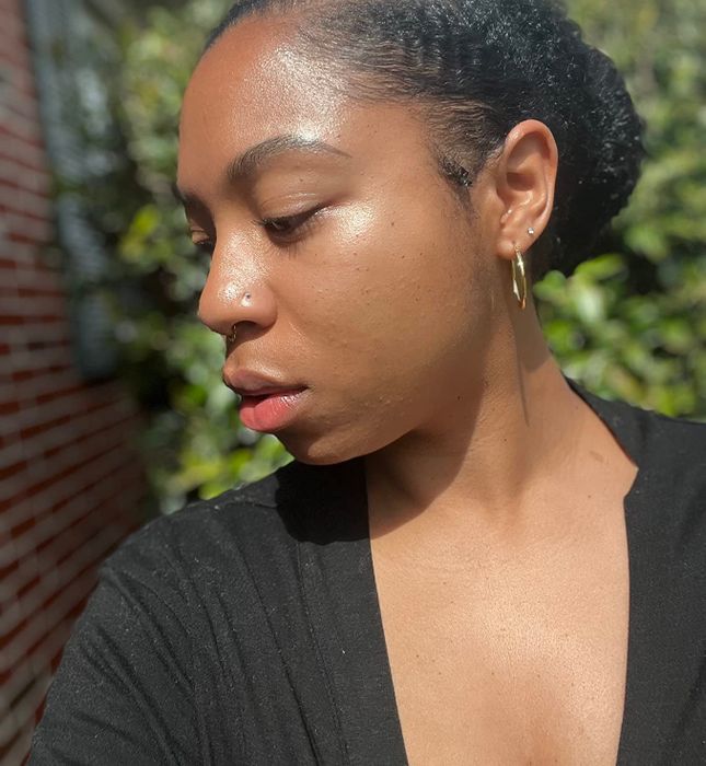 A reviewer glowing under the sun, wearing shimmering sunscreen.