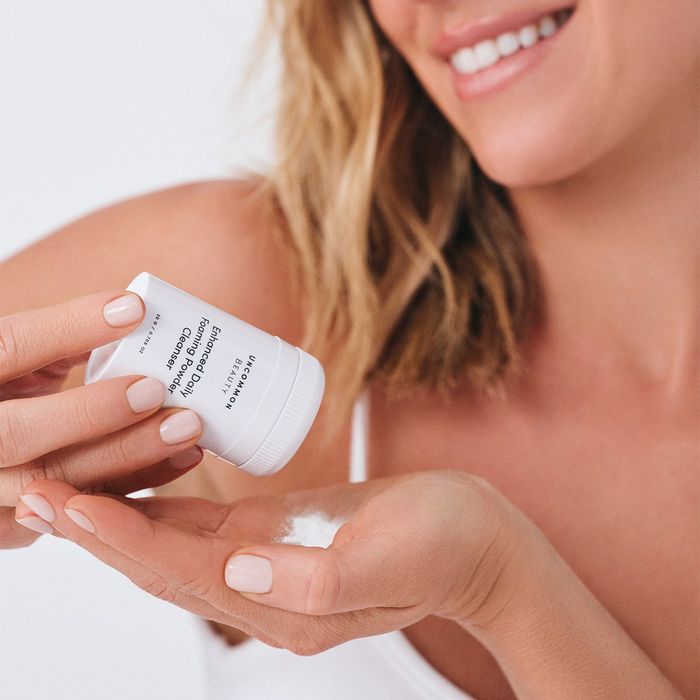 a model dispensing powdered cleanser into their palm