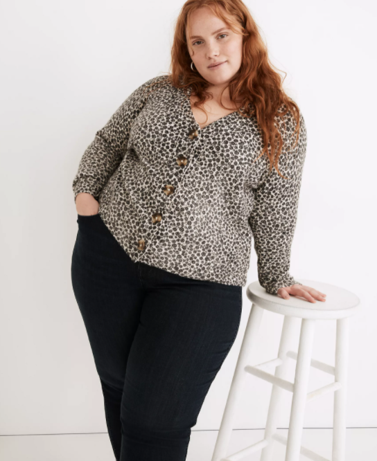 A model styled in a cardigan paired with black pants.