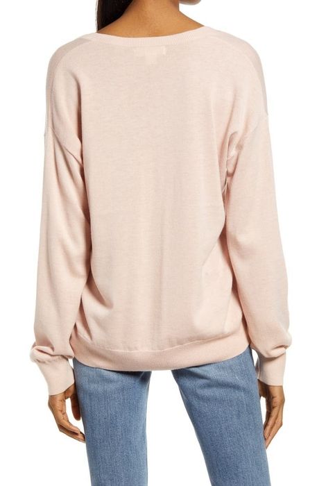 Model showing the back of a pink sweater