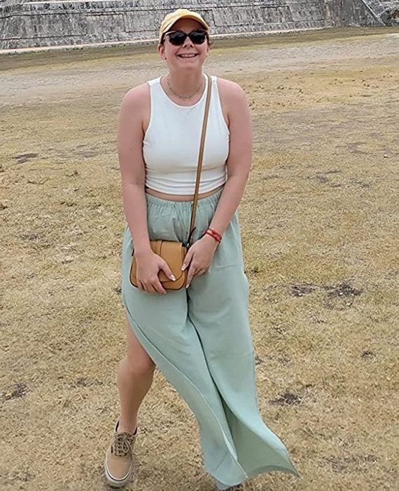 A reviewer is wearing a white crop top paired with a flowing maxi skirt.