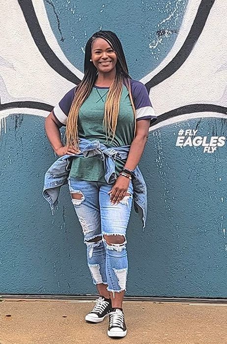 A reviewer is seen wearing a green, white, and black top.