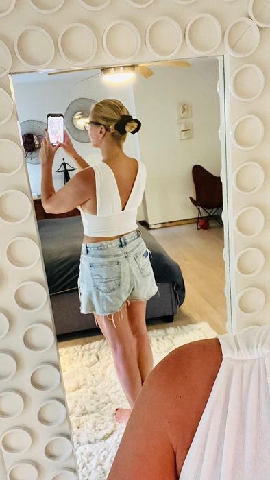 Back view of a reviewer wearing the top in white.