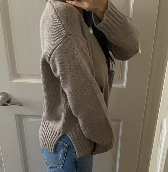 A reviewer dons a cardigan, showcasing its effortless style.