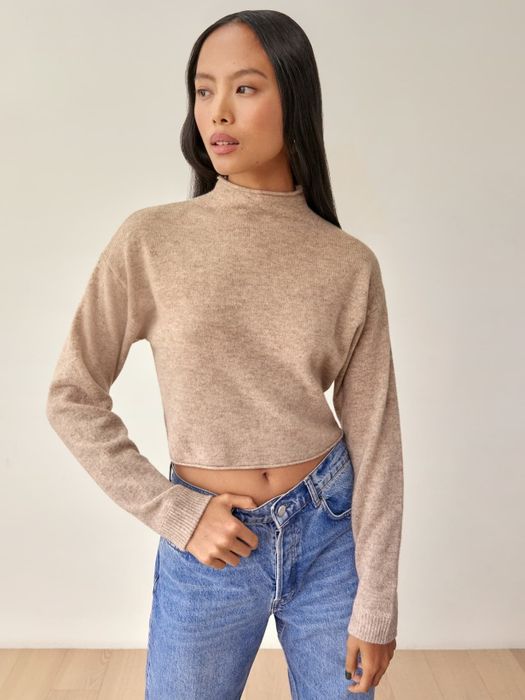 A model wearing the sweater in a soft 