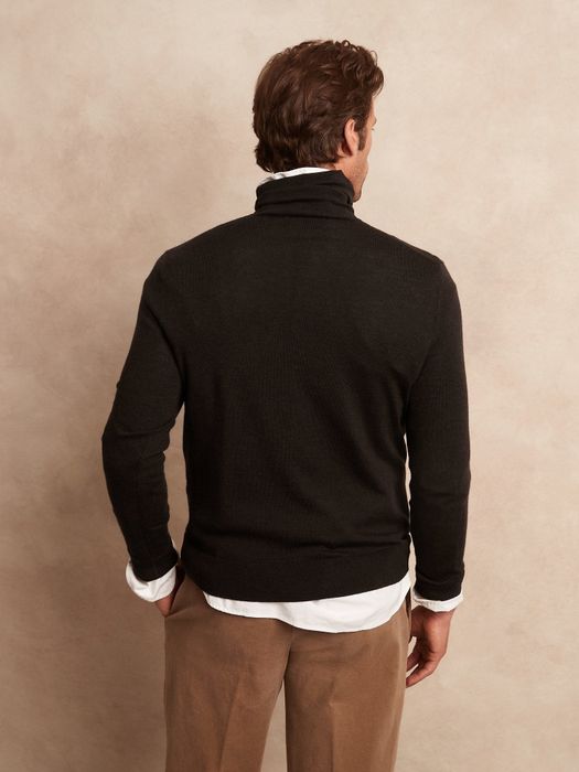 A model showcasing the back of a black sweater.