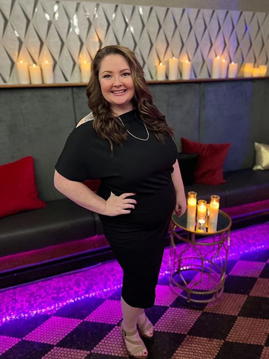 A reviewer is seen wearing a sophisticated black dress, highlighting its versatile elegance.