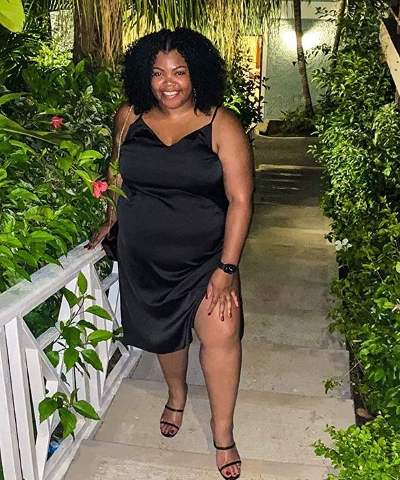 A reviewer showcasing the black dress