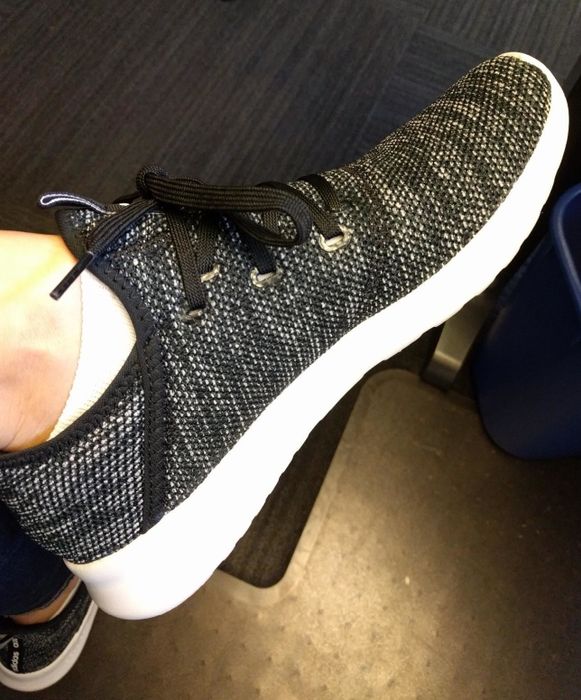 A side view of the reviewer wearing the sneakers, showcasing their slim profile and subtle lift.