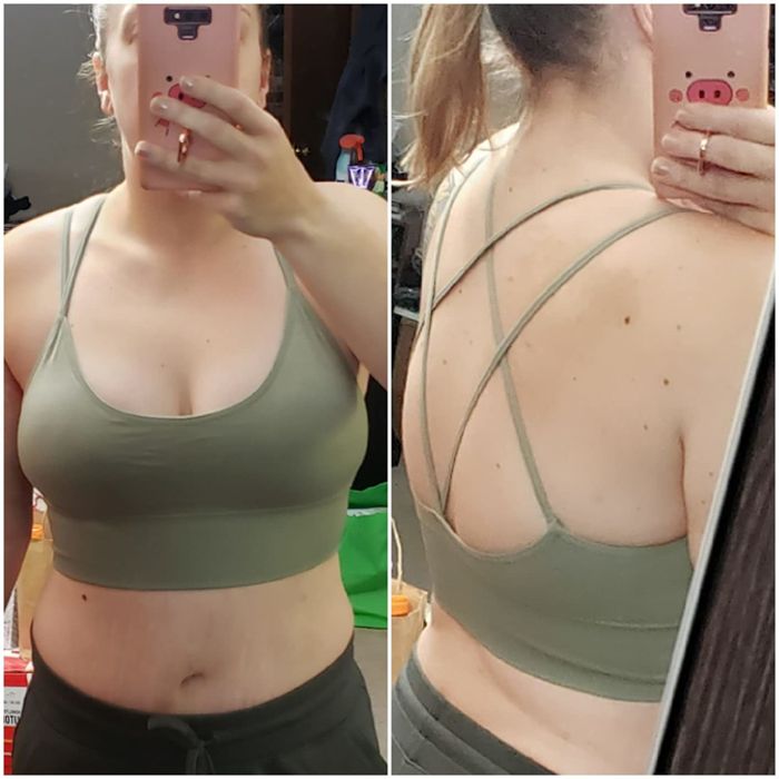 The reviewer is rocking a pale green sports bra with a crisscross back design.