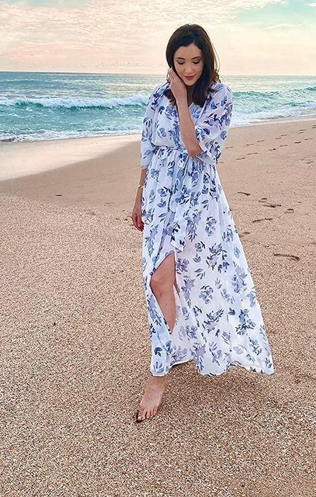 A reviewer in a floral white and teal dress shares her style and experience.