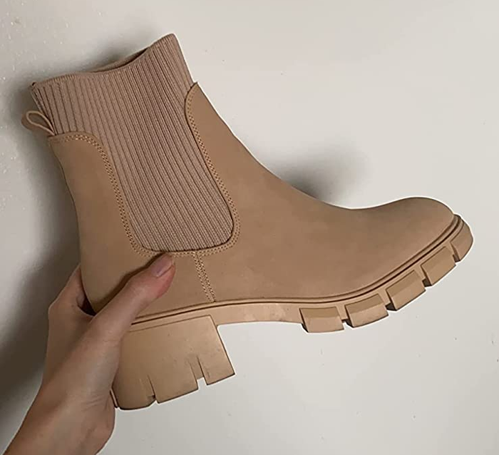 A reviewer holding a platform Chelsea boot in tan.
