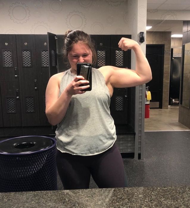 The reviewer is wearing a light grey tank top and black leggings.