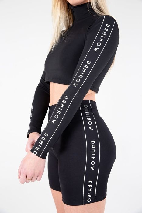 The model is seen wearing a black long-sleeve cropped top and shorts, with 'Damihow' printed on the sides.