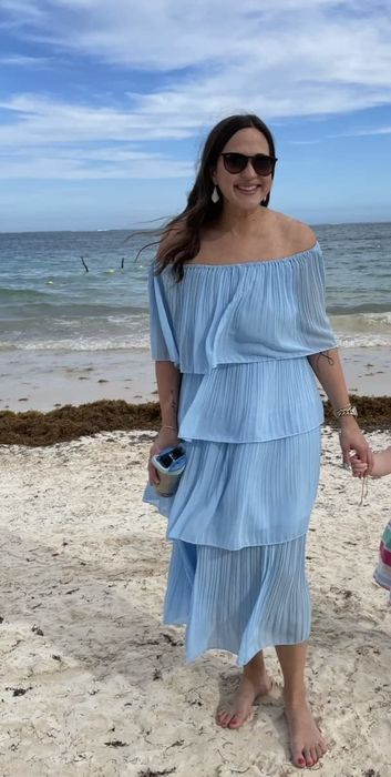 A reviewer in a blue dress shares their thoughts.