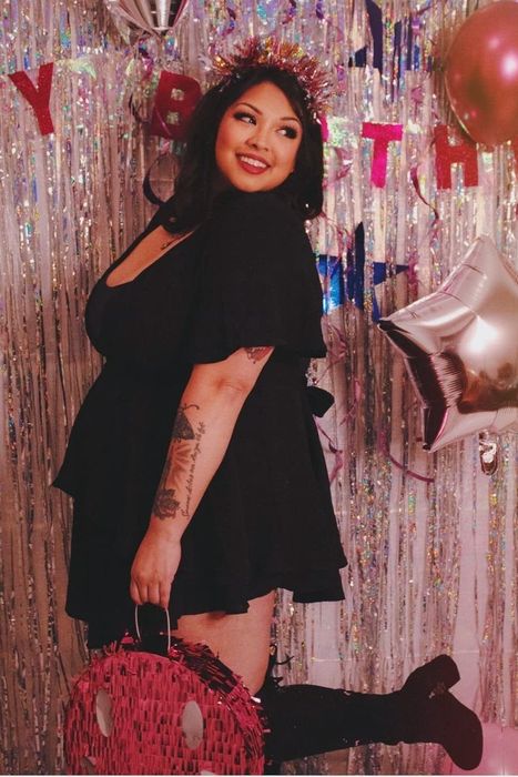 A reviewer in a black dress celebrating at a birthday party