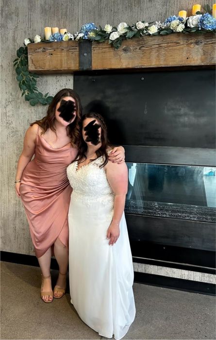 The reviewer, donning the dress, stands beside the bride, creating a perfect snapshot.