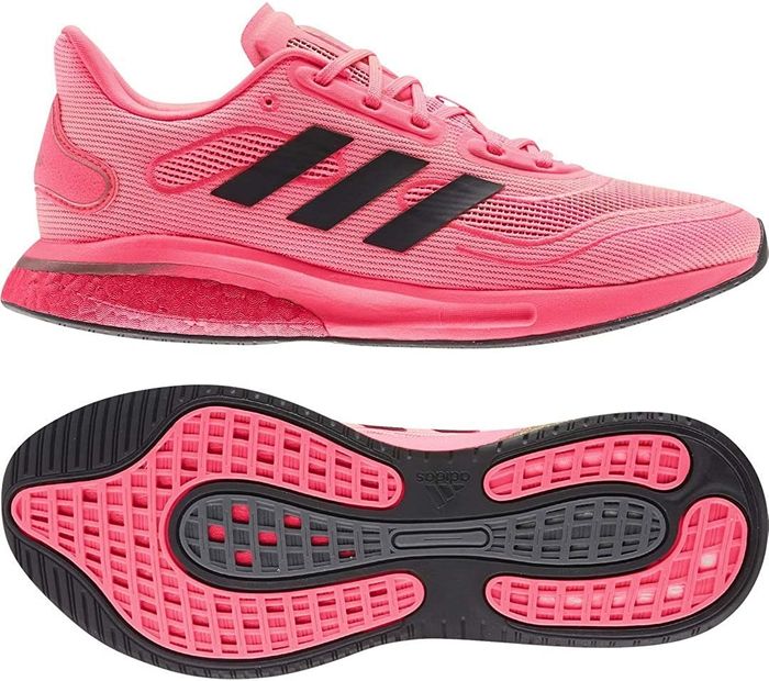These Adidas shoes in Signal Pink feature three black stripes along the side, a cushioned heel, and a textured sole for added grip.
