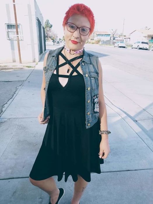 A reviewer shares their thoughts while wearing a black dress.