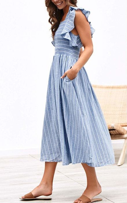 A side view of the model showing off the smocked-bust midi dress, highlighting its flattering fit and flowy design.