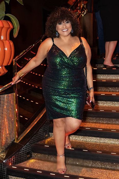 A reviewer in a dark green dress shares her experience and style.