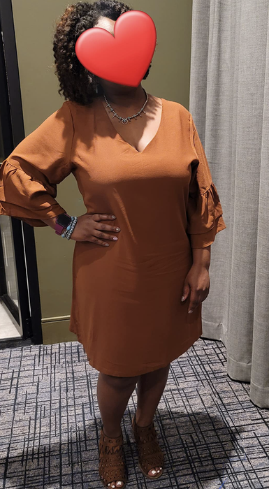 A reviewer in a vibrant orange version of the dress.