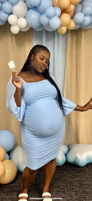 A pregnant reviewer confidently wears the dress, showcasing her baby bump