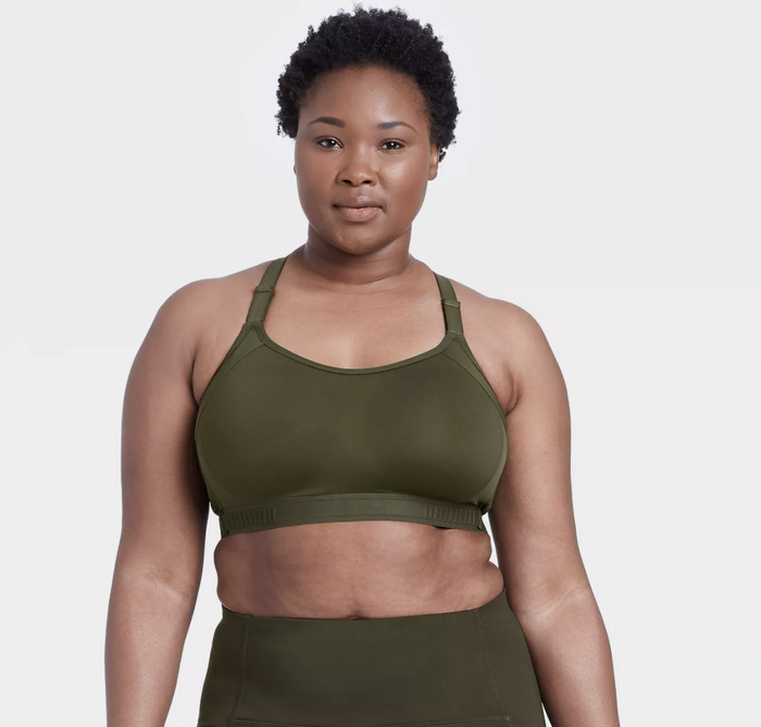 The model is sporting a forest green sports bra with matching leggings.