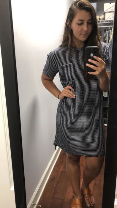 A reviewer in a navy and white striped dress shares their thoughts.