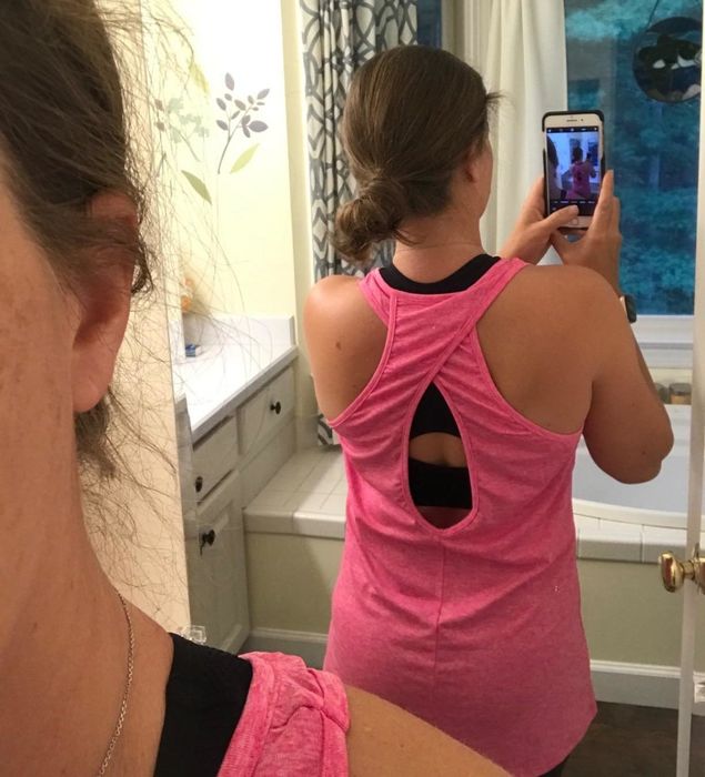 The reviewer is sporting a hot pink tank top featuring a crisscross design with a peep hole back for an extra touch of style.
