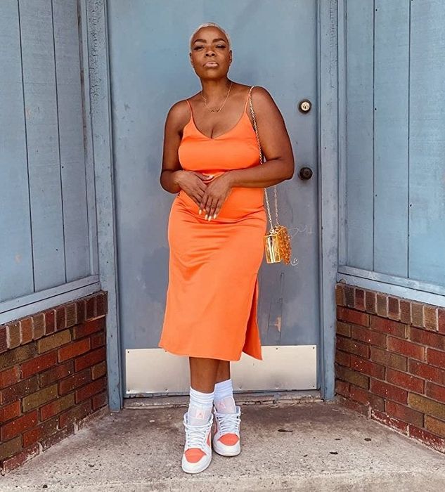 A reviewer wearing the bold fire orange dress