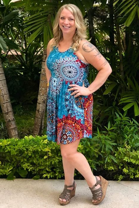 A reviewer showcasing a blue and red dress